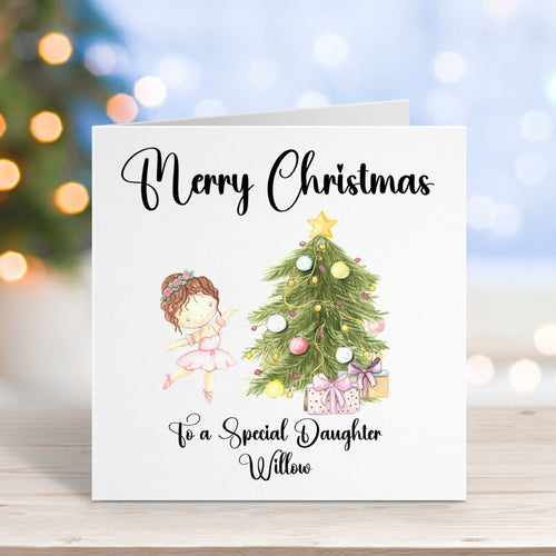 Christmas card with a girl and Christmas tree illustration on a wooden surface with blurred lights in the background.