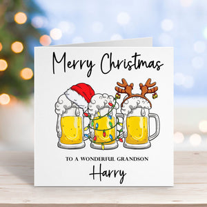 Christmas card with cartoon beer glasses wearing Santa hats and reindeer antlers, on a blurred festive background.