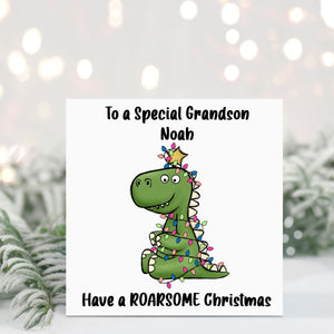 Christmas card with a dinosaur illustration and personalized text in front of a snowy background.