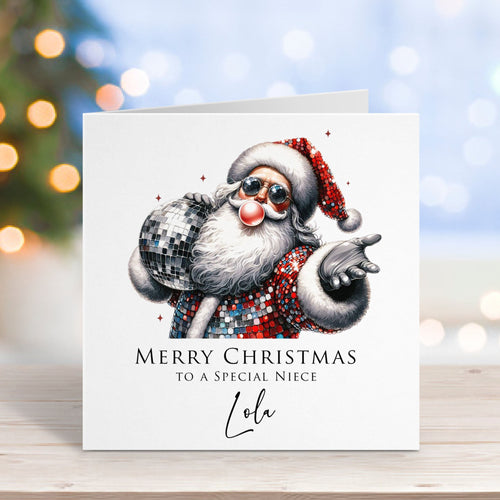 Christmas card with a modern Santa Claus design on a wooden surface with blurred lights in the background.