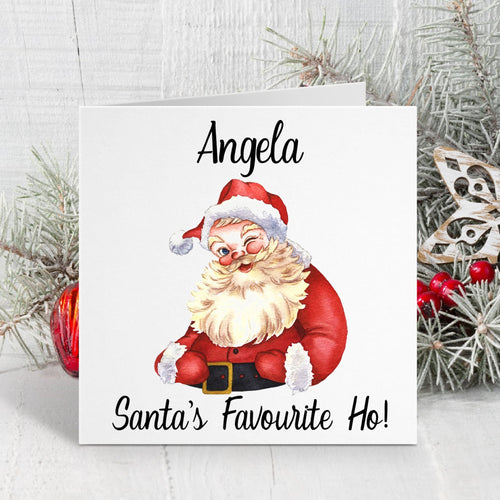 Christmas card with Santa Claus illustration and text 'Angela, Santa's Favourite Ho!' on a white background with decorative elements.