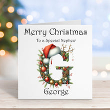Christmas card with a decorative letter 'G' and Santa hat, on a blurred festive background.