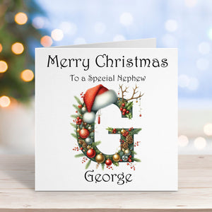 Christmas card with a decorative letter 'G' and Santa hat, on a blurred festive background.
