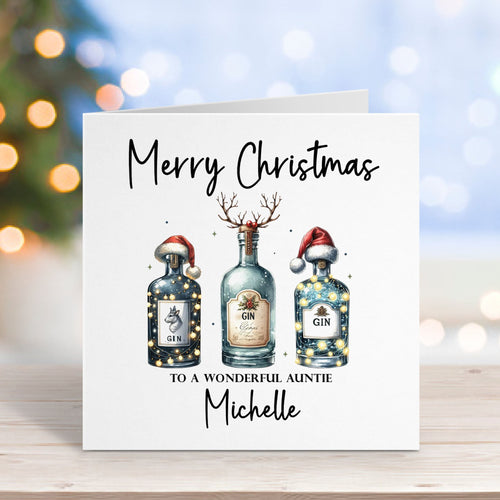 Christmas card with three gin bottles and personalized text on a blurred festive background