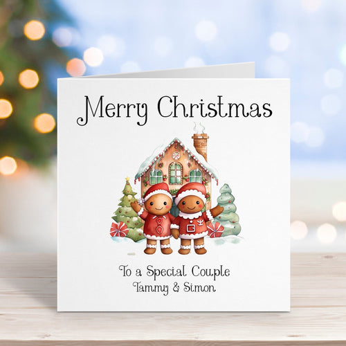 Christmas card with two children in front of a house, on a wooden surface with blurred lights in the background.