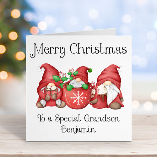 Christmas card with gnomes on a wooden surface with blurred lights in the background