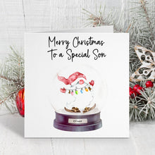 Christmas card with a snow globe featuring a Santa Claus figure and text 'Merry Christmas to a Special Son'.