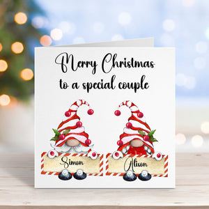 Christmas card with two gnomes and personalized names on a blurred festive background