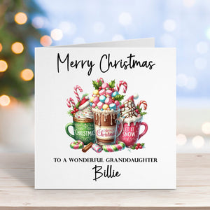Christmas card with hot chocolate mugs and candy canes on a wooden surface with blurred lights in the background