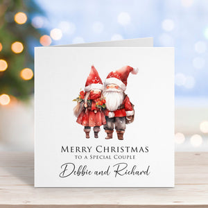 Christmas card with two gnomes and personalized text on a blurred festive background