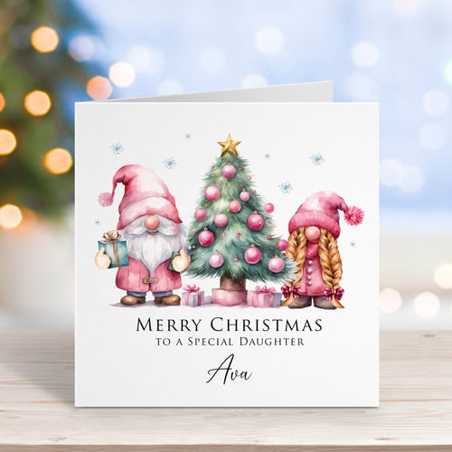 Christmas card with gnomes and tree on a wooden surface with blurred lights in the background