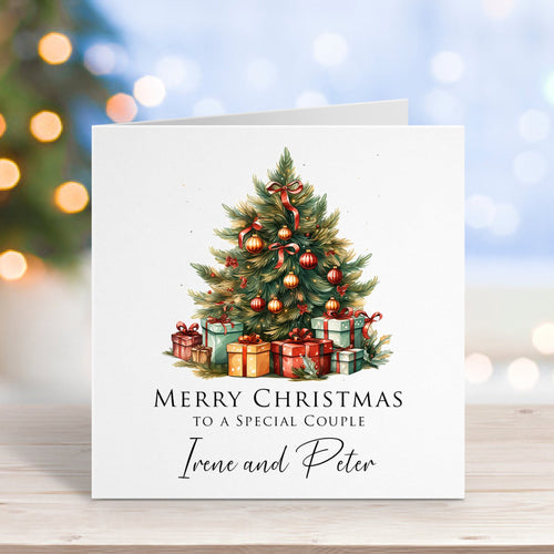 Christmas card with a decorated tree and presents on a wooden surface with blurred lights in the background