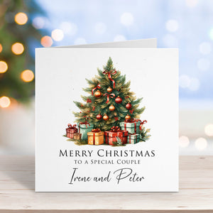 Christmas card with a decorated tree and presents on a wooden surface with blurred lights in the background