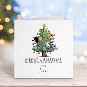 Christmas card with a tree of cats and text on a blurred festive background