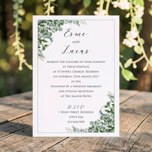 Esme evening wedding invitation with sage eucalyptus corners, a fine border and black script lettering, displayed with candles and greenery