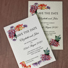 Alexia Save the Date cards in white and ivory sat on a brown wooden table